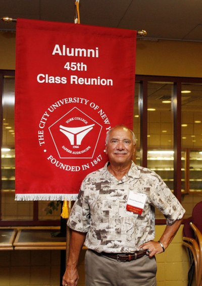 Alum posing with the 45th class Reunion banner